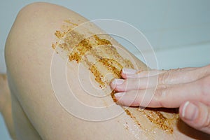 Closeup of female legs with coffee scrub. Cosmetology, spa, beauty concept