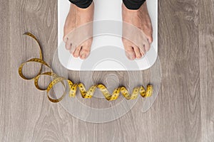 Closeup female legs on a measuring scale. Weight loss control concept