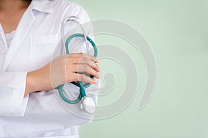 Closeup of female medical doctor is holding stethoscope on her a