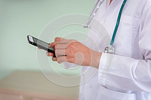 Closeup of female medical doctor is using smart phone