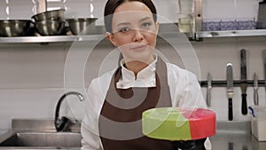 Closeup of female pastry chef preparing a mousse cake in a pastry kitchen.