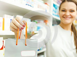 Closeup of a female pharmacist holding packet in her hand at drugstore