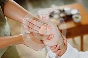 Female receiving hand massage at health spa salon.