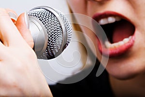 Closeup on female singer mouth and microphone