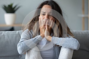 Closeup of female sitting on couch looking unhappy and desperate