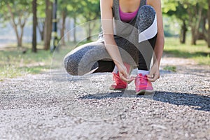 closeup of female sport fitness tying shoe