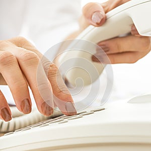 Closeup of female telephone operator dialing a phone number