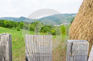 closeup of a fence with garden and hay in the background