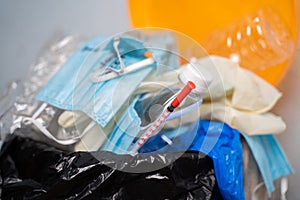 Closeup of Filed or over flowed single use Medical waste like face masks, gloves and syringe on garbage can or trash bin at