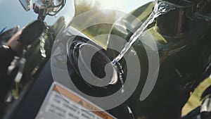 Closeup of fill gasoline motorcycle. Stock. Close-up of reflection of man in chrome detail of motorcycle. Motorcyclist