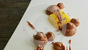 Closeup finely decorated fruit and chocolate mousse dessert spinning on plate