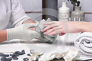 Closeup finger nail care by manicure specialist in beauty salon.