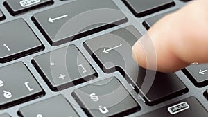 Closeup finger pressing enter key on modern laptop keyboard footage 4k