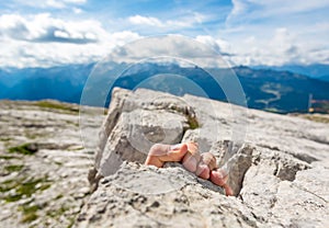 Closeup of fingers gripping a rock.