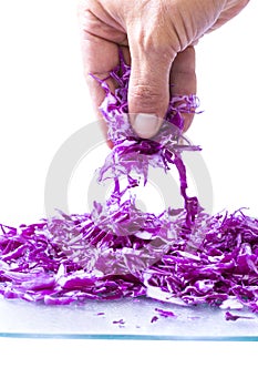 Closeup fingers picking up pinch of red cabbage