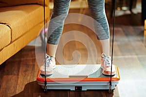 Closeup on sports woman training using vibration power plate photo