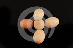 Closeup of five fresh eggs on a black surface