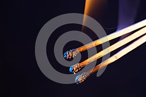 Closeup of flaming match sticks isolated on a dark background