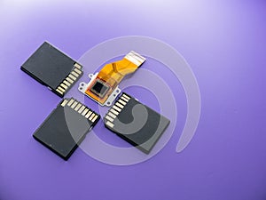 Closeup flat lay of a digital camera Ccd sensor and black SD cards on a purple background photo