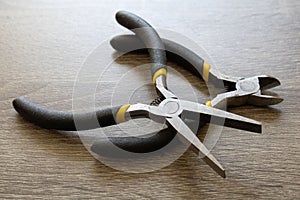 Closeup of flat nose pliers and wire cutter pliers on a table