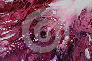 Closeup of a flowing abstract acrylic pour painting in shades of pink and white.