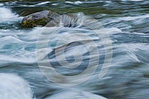 Closeup of flowing water with sea green and blue colors