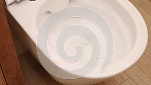 Closeup Flush Toilet, Cleanliness. Water Flushes, Rinses The White Toilet Bowl In Bathroom