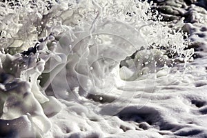 A closeup of the foam generated when a wave breaks on the shore.