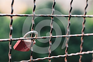 Closeup focus shot of a love lock attached to a grate