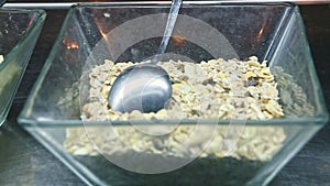 Closeup focus in at transparent glass bowl with oat cereal granola with dry fruits