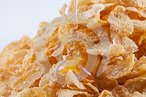 Closeup foe corn flakes with honey dropped