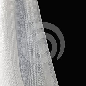 A closeup of the folds of white nylon netting on black.