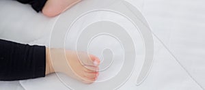 Closeup foot of asian little baby girl sleeping on bed in the bedroom at home.