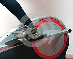 Closeup of foot in sport shoe on crosstrainer