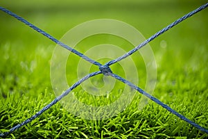 Closeup football field netting with green artificial grass background