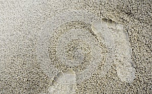 Closeup footprint in the sand beach background.