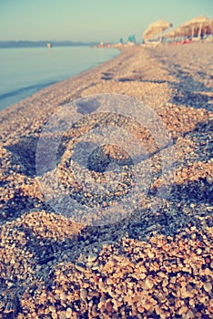 Closeup of footprints on the pebbly beach in summer; faded, retro style