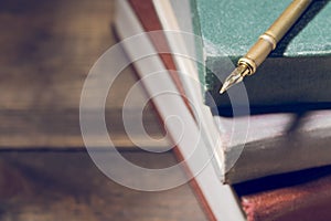 Closeup of fountain pen on stack of old books