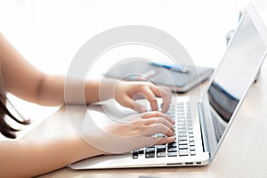 Closeup freelance asian woman working and typing on laptop computer at desk office with professional