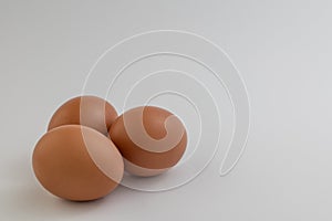 Closeup of fresh brown eggs over white background