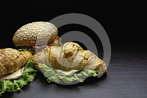 Closeup fresh burgers placed on a wooden plate in dark background