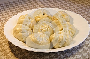 Closeup of fresh Chinese steamed meat buns in white plate, homemade gourmet food