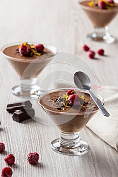 Closeup of fresh chocolate mousse and raspberry in a glasses.