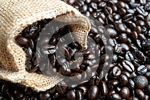 Closeup Fresh Coffee beans in bag made from burlap on wooden surface