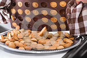 Closeup of fresh cookies in halved walnut shape at falling from brown silicone baking mold