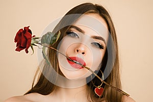 Closeup fresh face girl. Brunette woman with red rose. Beautiful girl with reses flowers. Closeup face of young photo