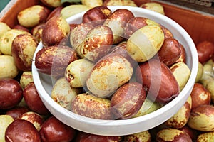 Closeup of fresh jujube fruit in a bowl.