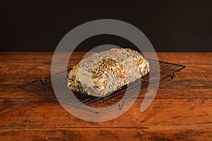 Closeup of a fresh loaf of bread with sesame seeds on a metal tray on the table