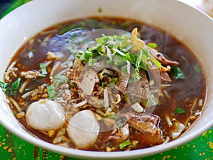 Fresh noodles soup with pork and its tasty thick broth Guay Tiao Nam Tok Moo - delicious and healthy street food in Thailand