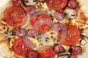 Closeup of fresh prepared and hot pizza with mushrooms, tomatoes, cheese, grilled sausage and tomatoes sauce